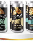 Three cans of Swish cocktails on a white stand with a gold accent.
