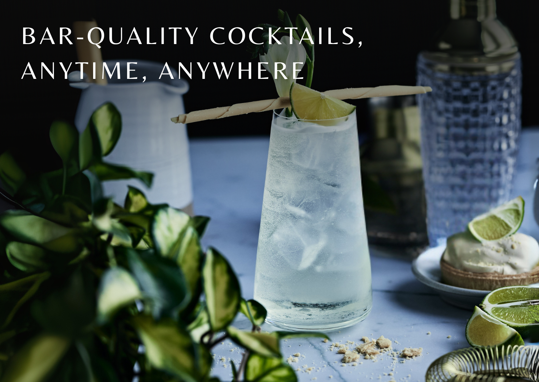 Cocktail with lime garnish on a table with text 'Bar-quality cocktails, anytime, anywhere'.
